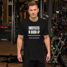 Undefeated In Warm Up black unisex t-shirt worn by a model -- pickleball court style